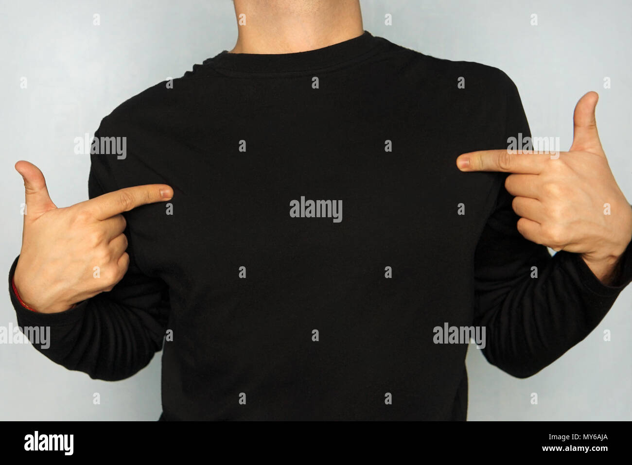 Werbung, Design und Kleidung Konzept. Positive modischen jungen Kerl in Brillen zeigt Kopie Platz auf seinem Blank Top für Ihre werbe Text, infor Stockfoto