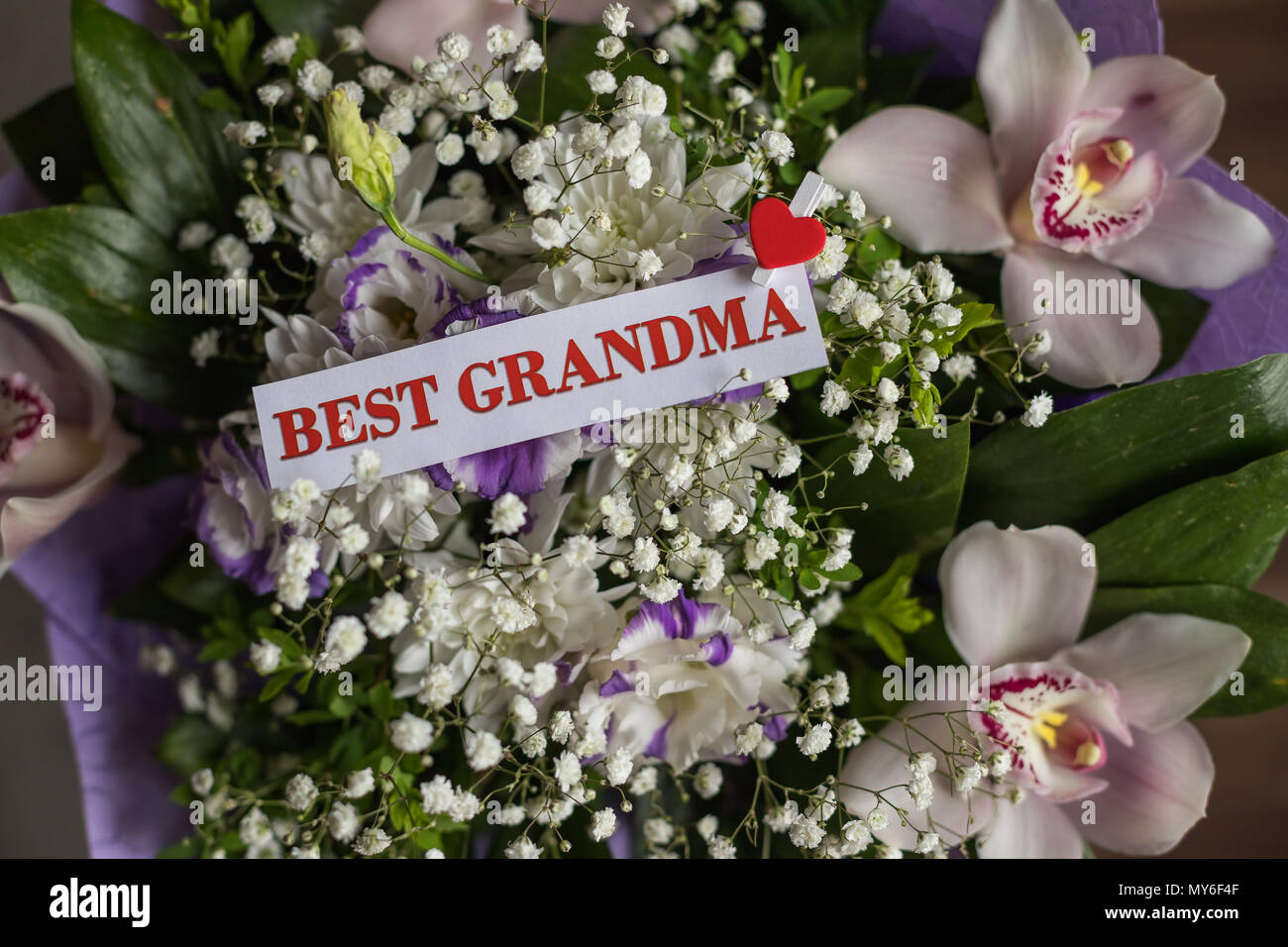 Schöne Blumen Geschenk für Großeltern-Tag mit Grußkarte. Ansicht von oben, close-up. Herzlichen Glückwunsch für lieben. Strauß Orchideen für Oma. Beste Großeltern jemals Stockfoto