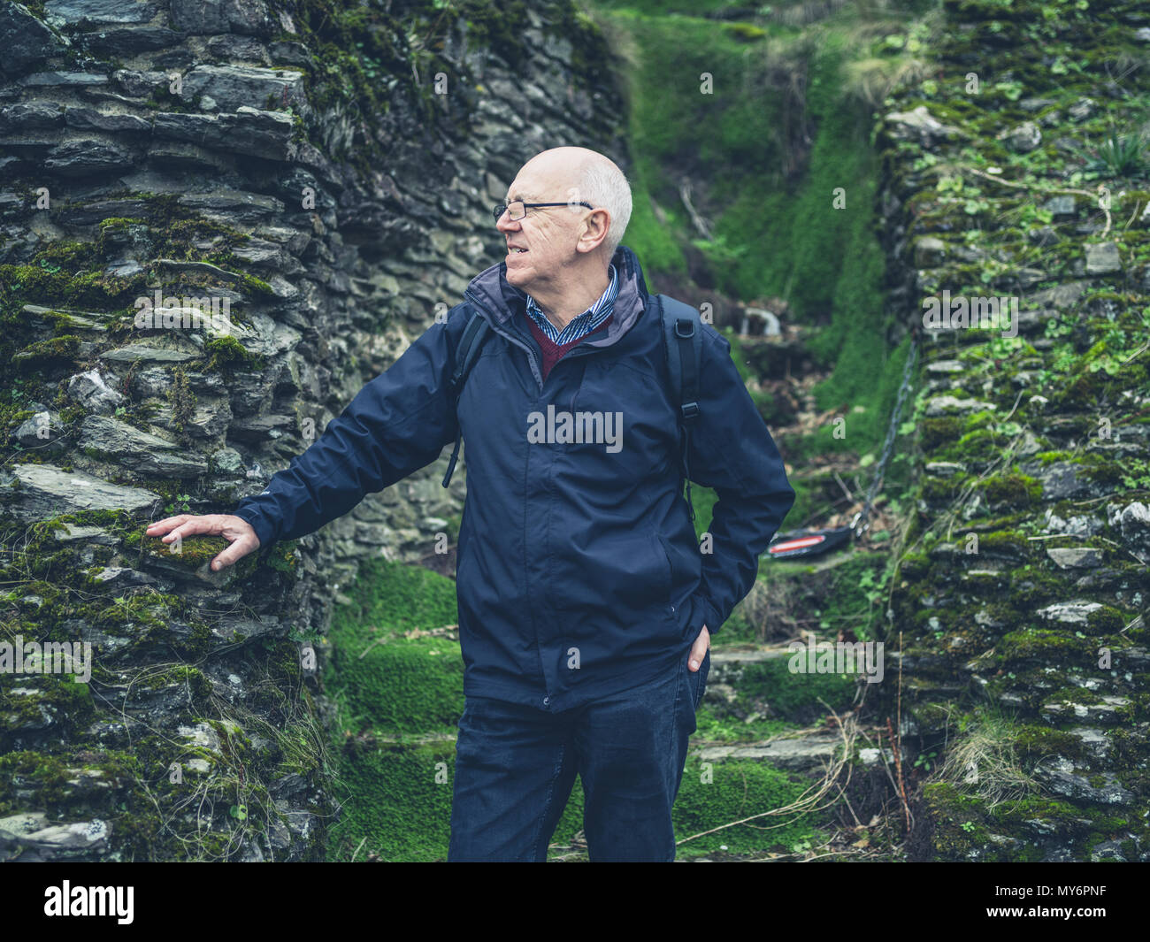 Ein älterer Mann steht durch einige Schritte in Moos in der freien Natur abgedeckt Stockfoto