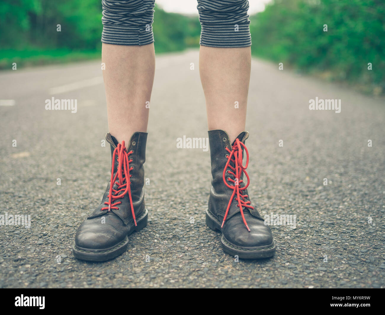 Die Füße einer jungen Frau trägt Stiefel mit roten Schnürsenkel im Freien  Stockfotografie - Alamy