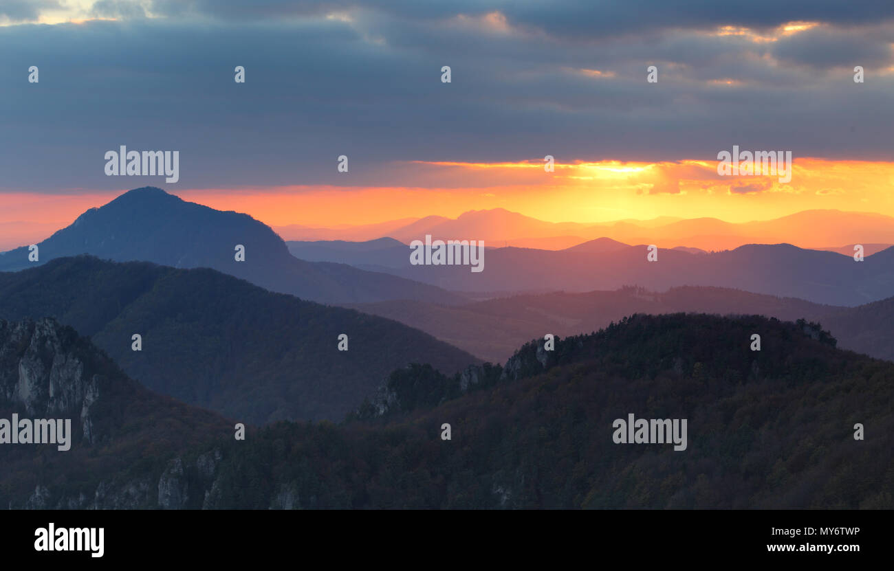 Dramatischer Sonnenuntergang Strahlen hinter der Silhouette der Berge Stockfoto