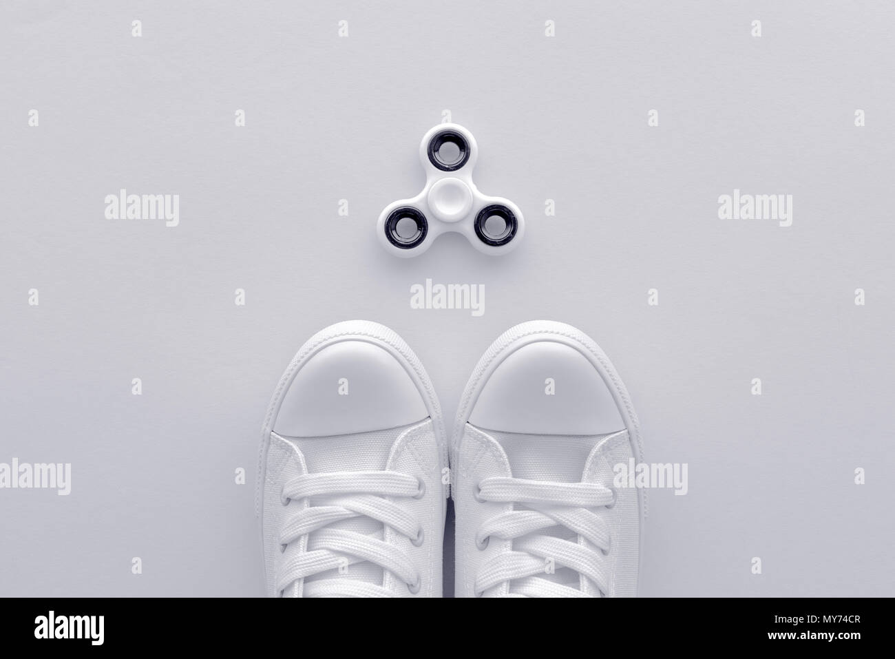 Turnschuhe und zappeln Spinner flay legen Draufsicht minimalistische Komposition Stockfoto