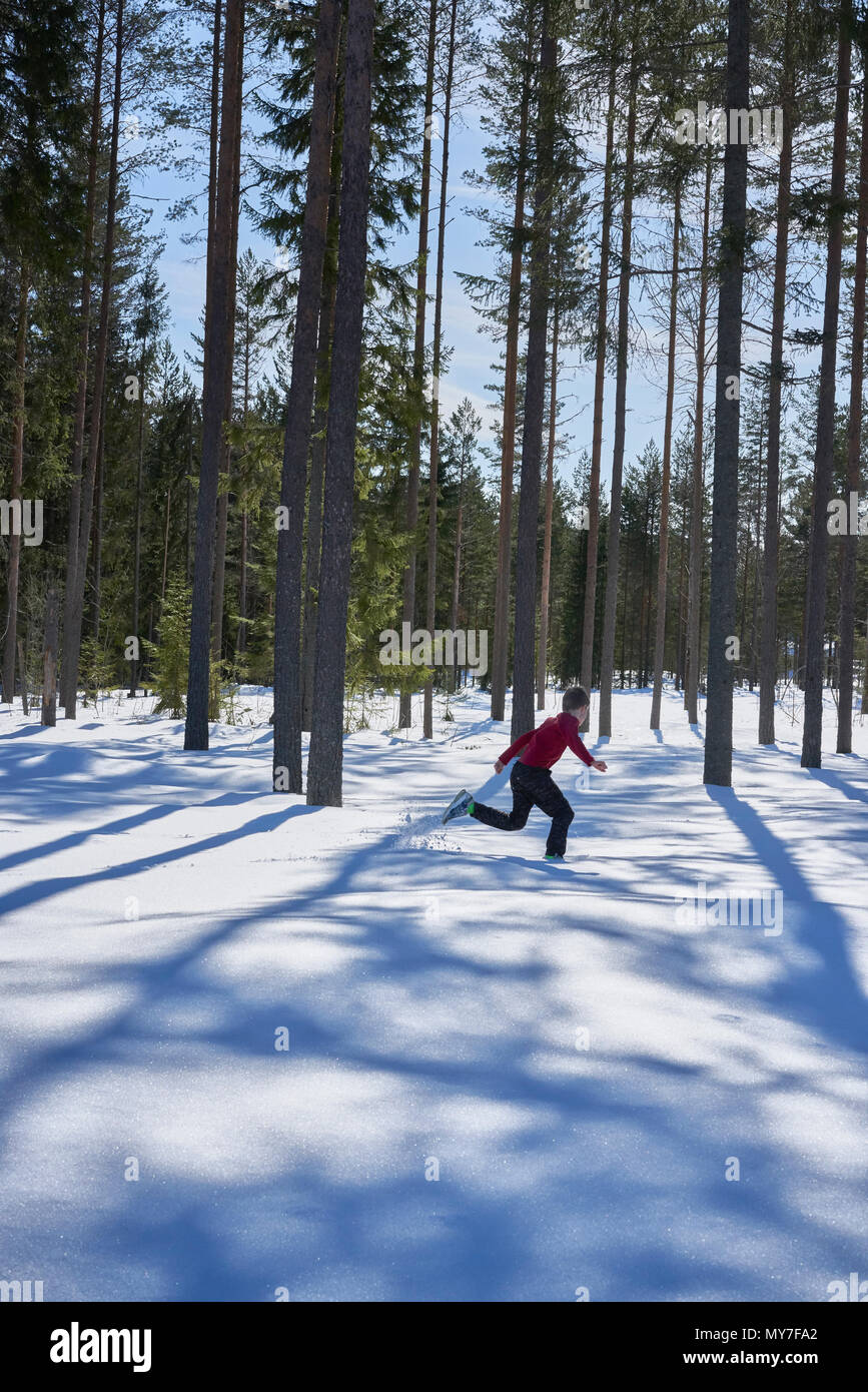 Junge in Schnee bedeckte Landschaft läuft Stockfoto