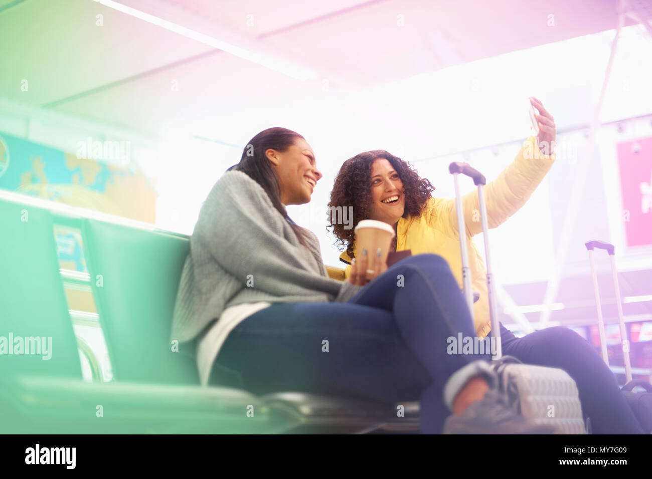 Zwei erwachsene Frauen, die in den Flughafen Abflughalle selfie Stockfoto