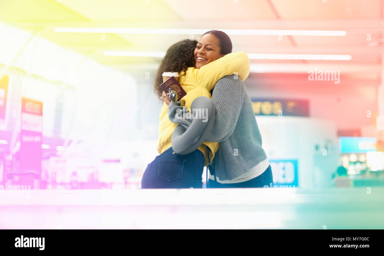 Zwei erwachsene Frauen umarmen in Flughafen Abflughalle Stockfoto