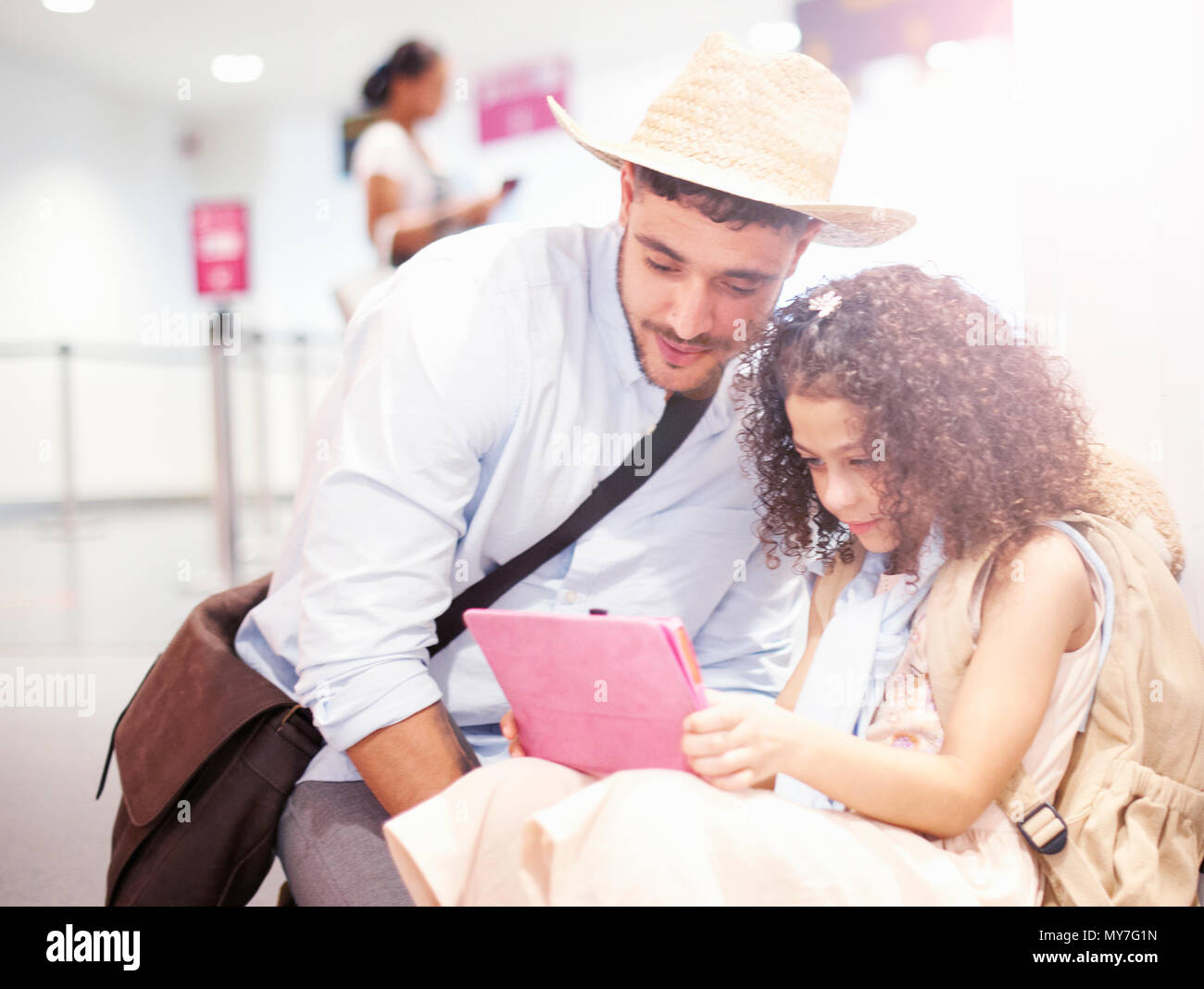 Vater und Tochter am Flughafen sitzen, mit Blick auf die digitale Tablet Stockfoto