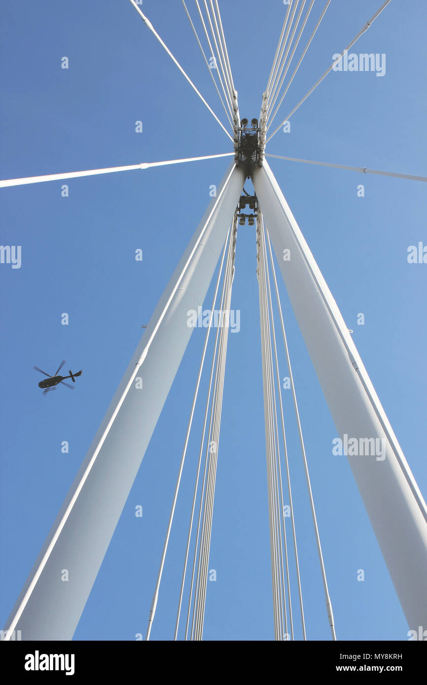 Ein Helikopter fliegt über Hungerford Bridge in London. Stockfoto