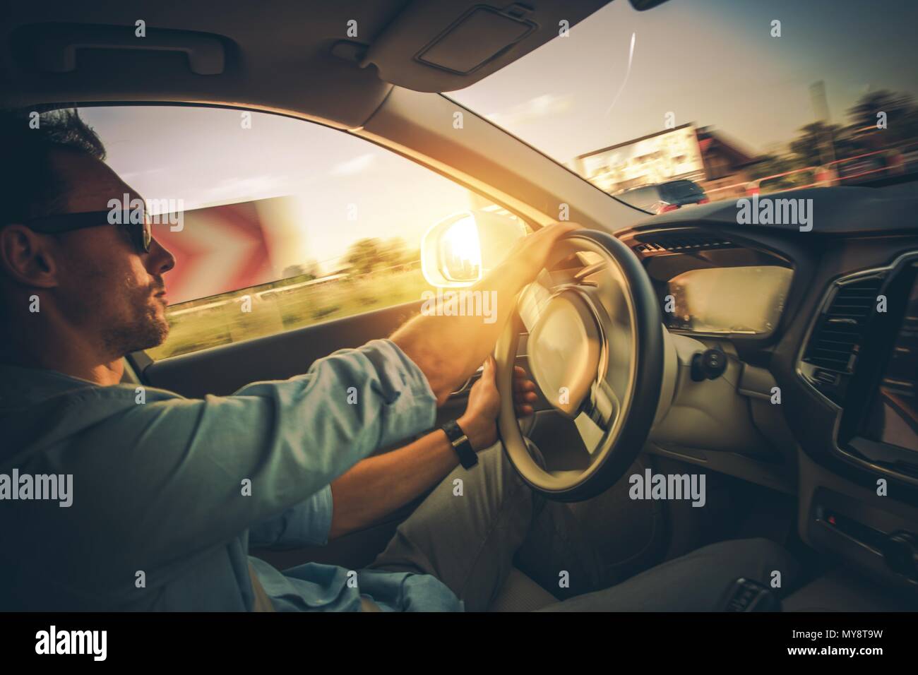 Auto mit Bewegungsunschärfe. Dynamisches Fahren an den Ecken. Kaukasische Fahrer in seinem 30s innerhalb der modernen Auto. Stockfoto