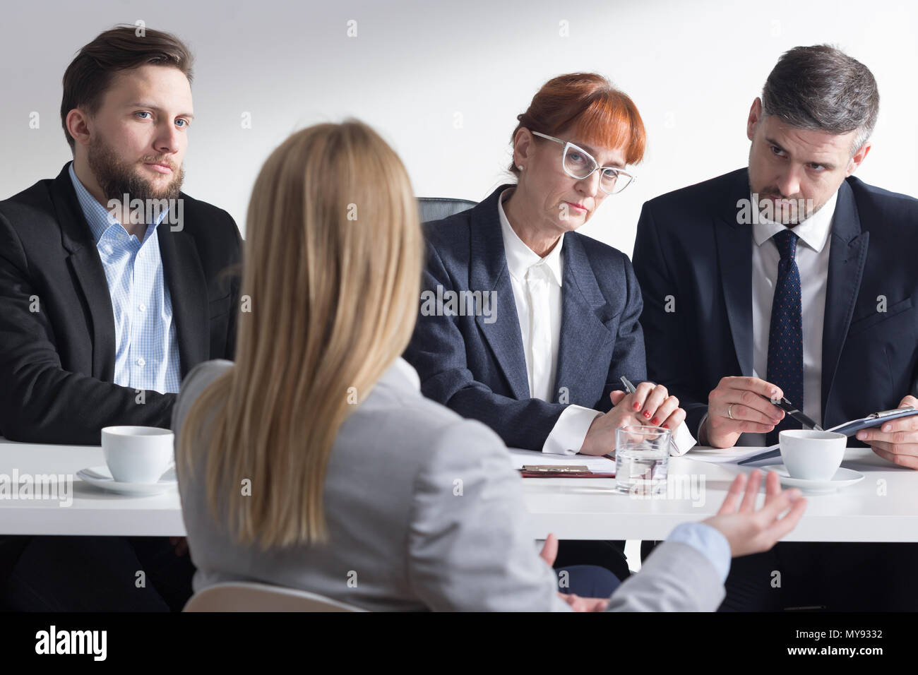 Frau von hinten während des Interviews und drei Corporate Arbeitnehmer Stockfoto