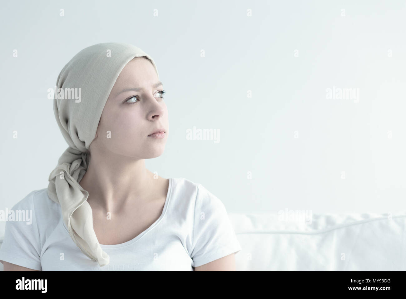 Frau nach der Chemotherapie, die ihren Kopf mit weißen Schal Stockfoto