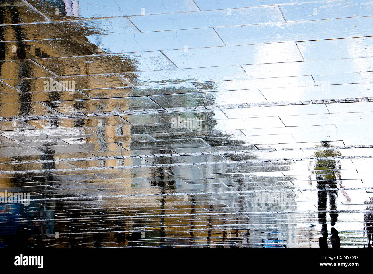 Unscharfe Reflexion Schatten Silhouetten von einem Mann an einem regnerischen Fußgängerzone an einem Sommertag Stockfoto