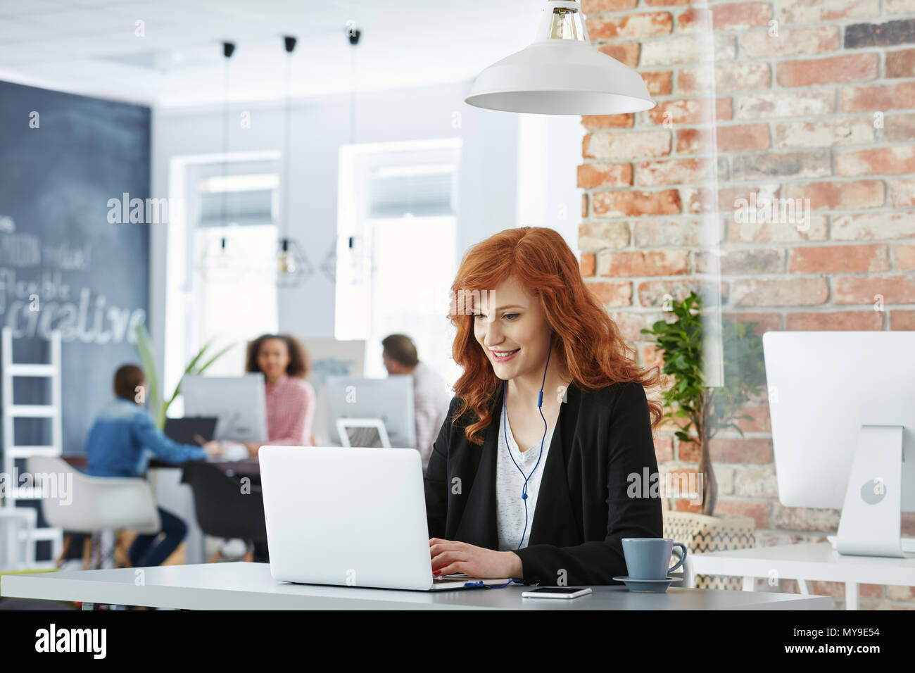 Happy Geschäftsfrau Arbeiten in modernen Büros mit Laptop Stockfoto