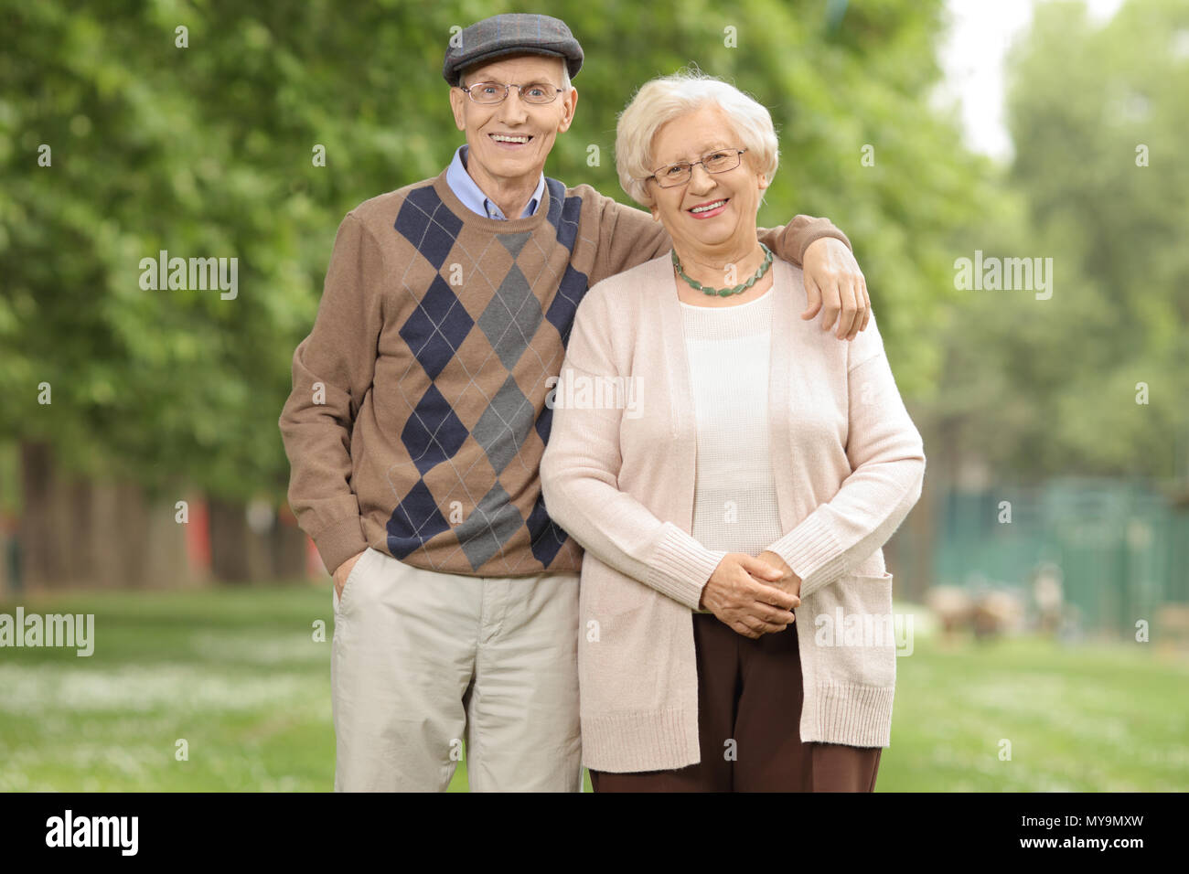 Reifes Paar schauen in die Kamera lächeln und im Freien Stockfoto