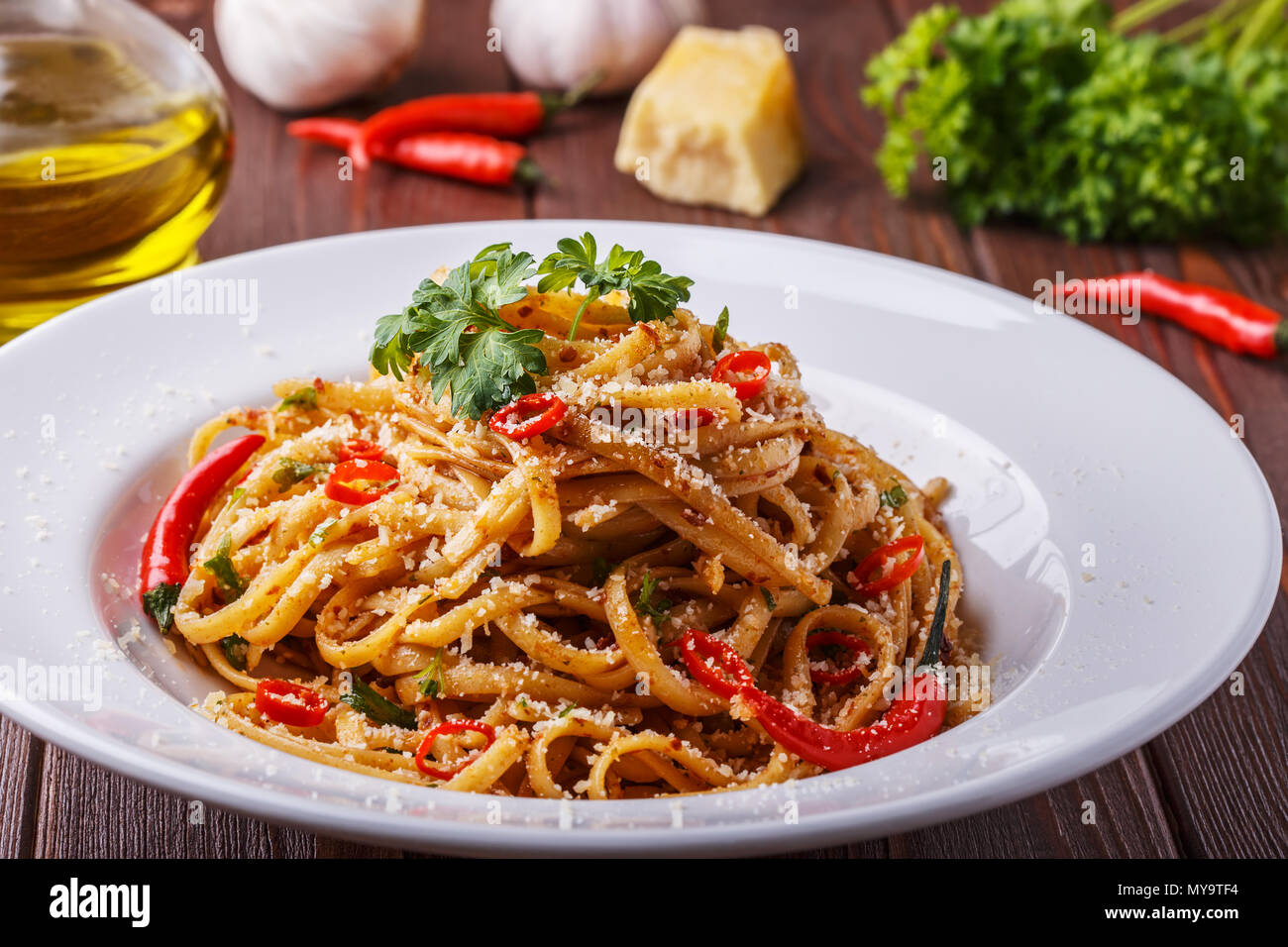 Hausgemachte linguine Pasta in Arrabbiata Sauce serviert mit Parmesan und Petersilie. Stockfoto