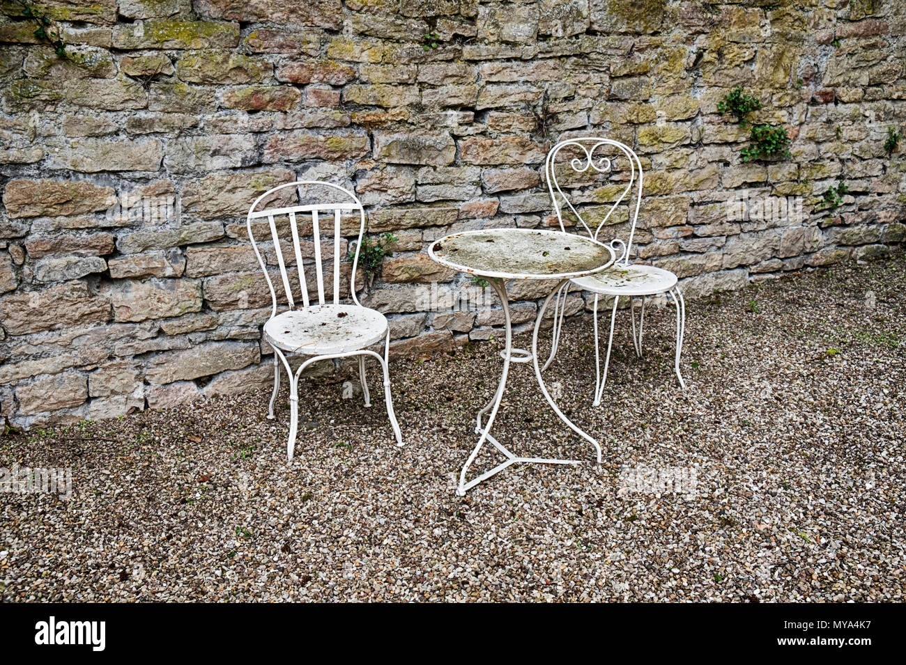 Ein weißer Tisch und zwei Stühle bilden eine schöne, ruhige Gegend, in einem kleinen Garten Hof in die Stadt Beaune in der Region Burgund in Frankreich. Stockfoto