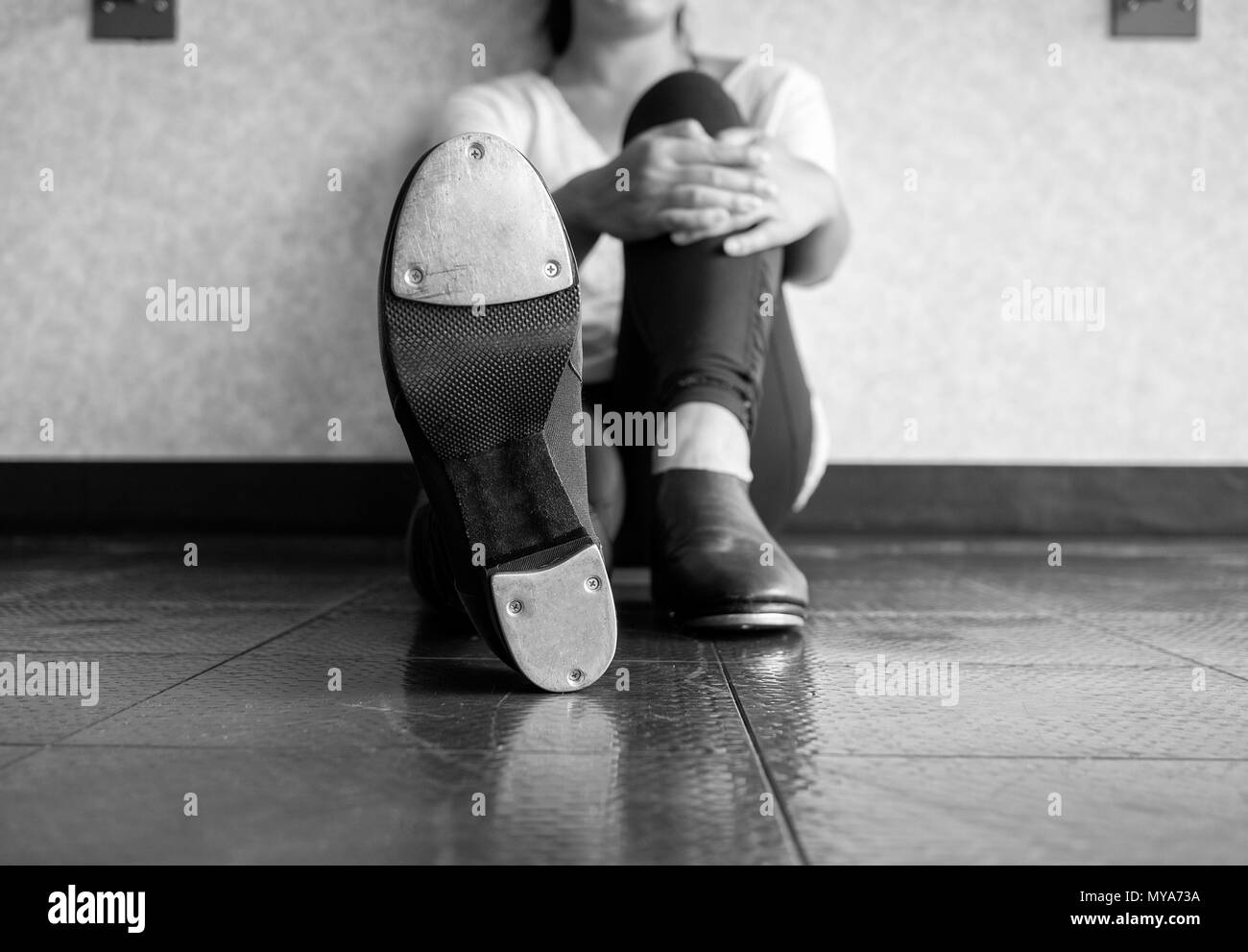 Schwarze und weiße Version von Tap dancer Lounging und zeigen ihre Schuhe, tippen Sie auf Stockfoto