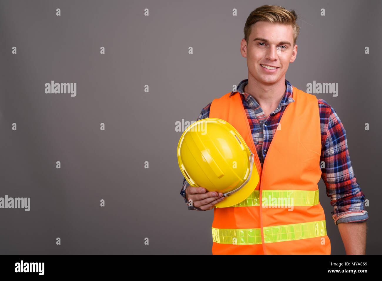 Jungen gutaussehenden Mann Bauarbeiter mit blonden Haaren gegen g Stockfoto