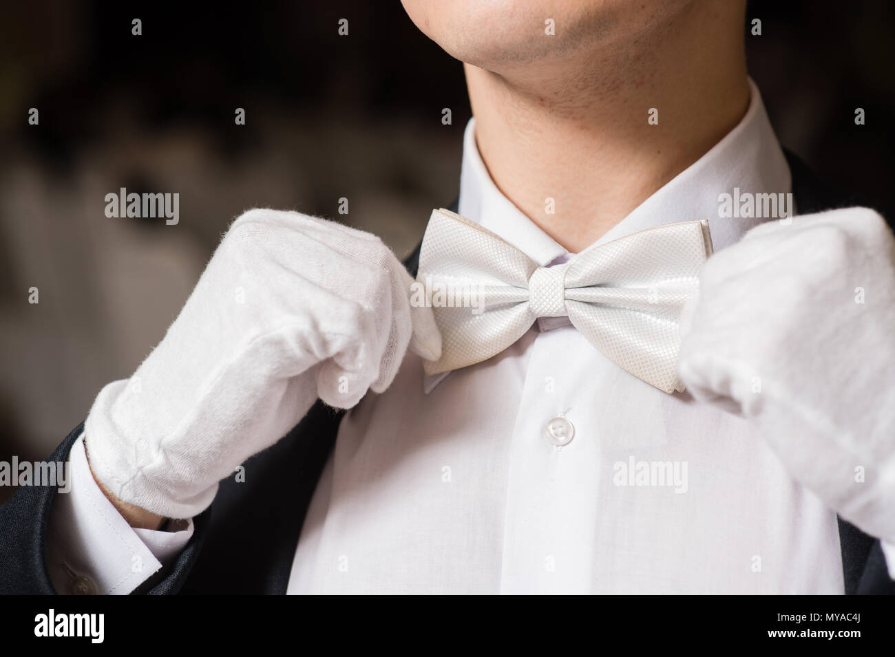 Gentleman tippen Sie auf seine weiße Fliege Stockfoto