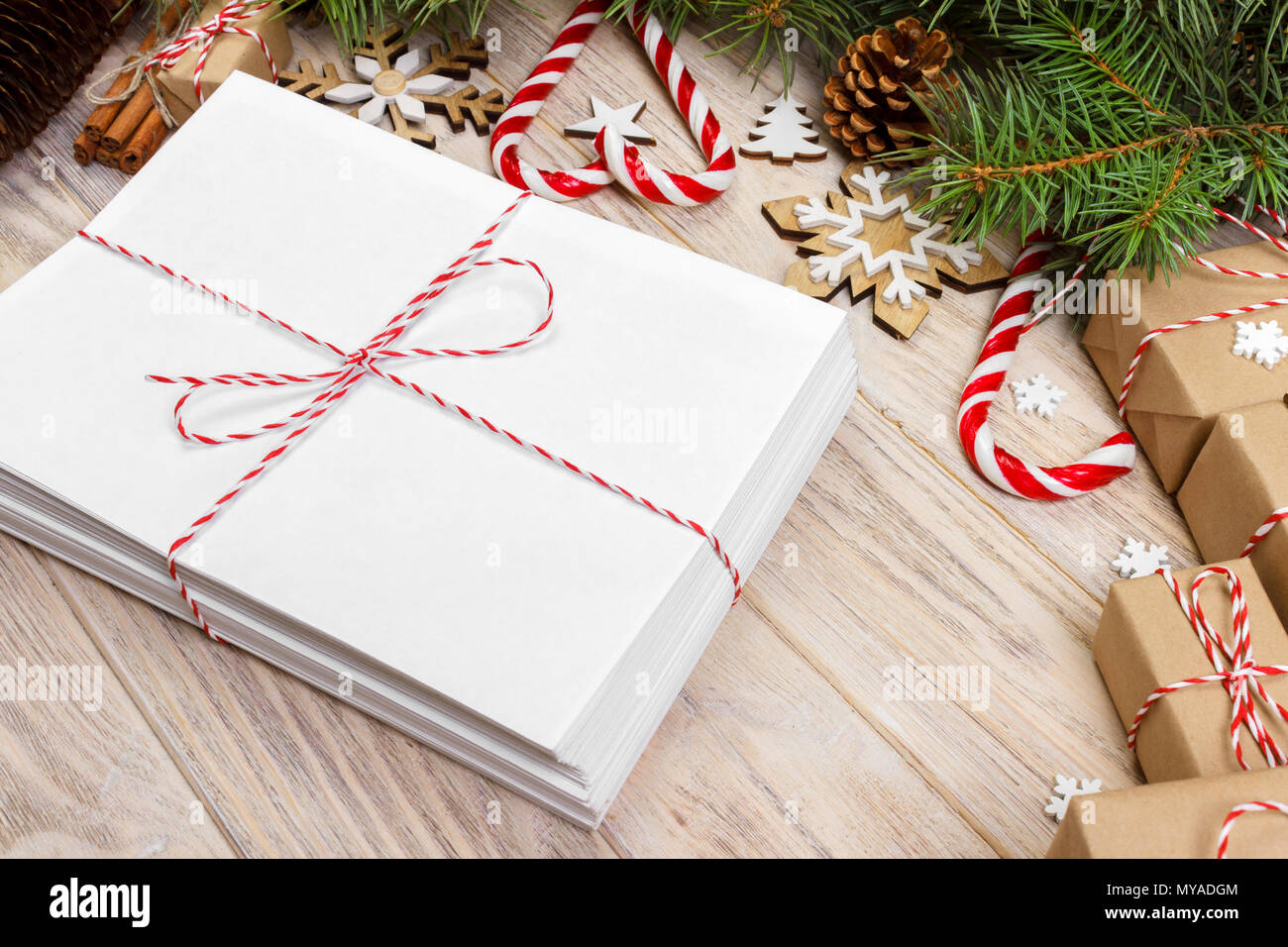 Umschlag mit leeren Blatt Papier auf Weihnachten Hintergrund-fir Zweig, Tannenzapfen, red ribbon, Sterne und Herzen von Süßigkeiten. Platz für Ihren Text. Stockfoto