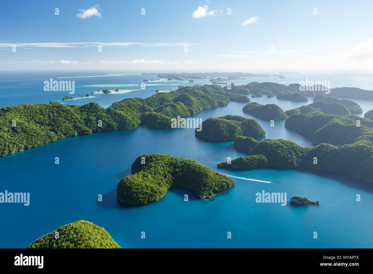 Luftaufnahme von Boot unterwegs thru Korallenriffe, Korallenatolle und Labyrinth der klumpig Inseln umgeben vom türkisblauen Wasser des Südpazifik Stockfoto
