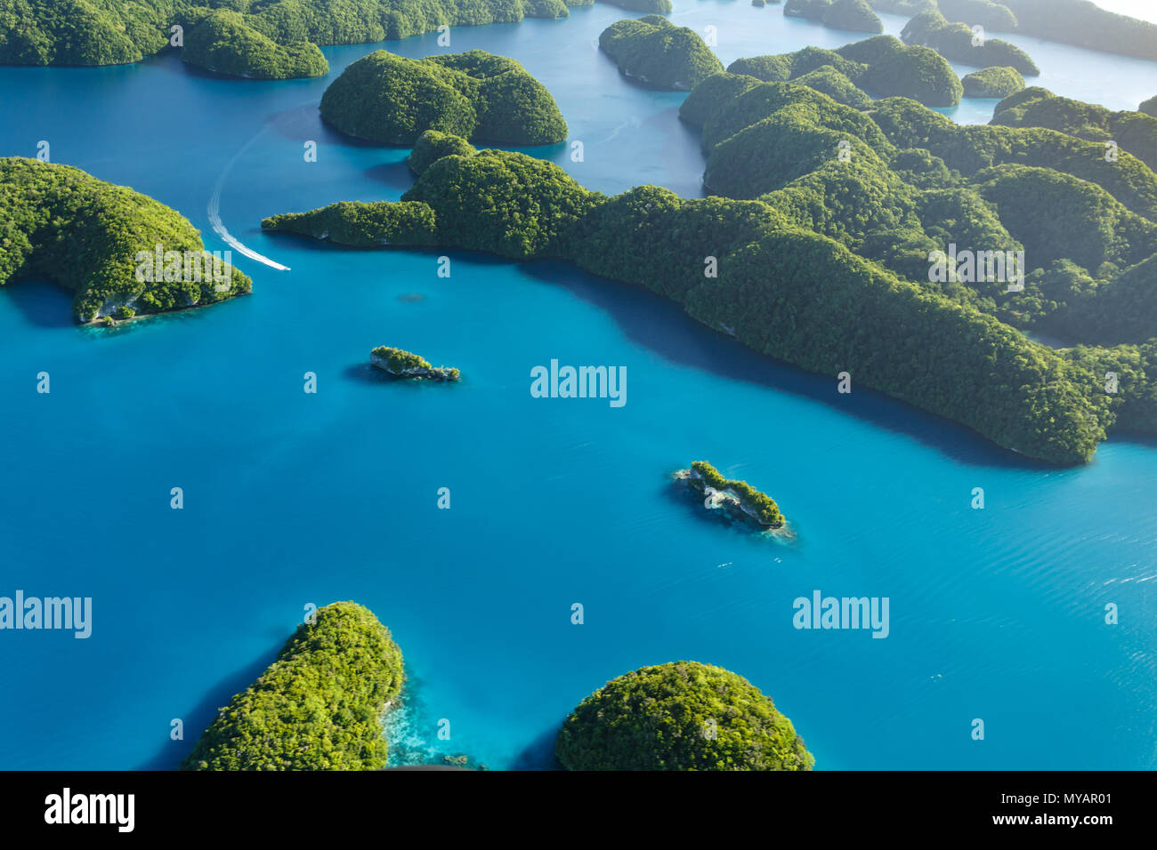 Luftaufnahme von Boot in neugierig mustern der Korallenriffe reisen, Korallenatolle und zwei kleinen Inseln umgeben vom türkisblauen Wasser des Südens Stockfoto
