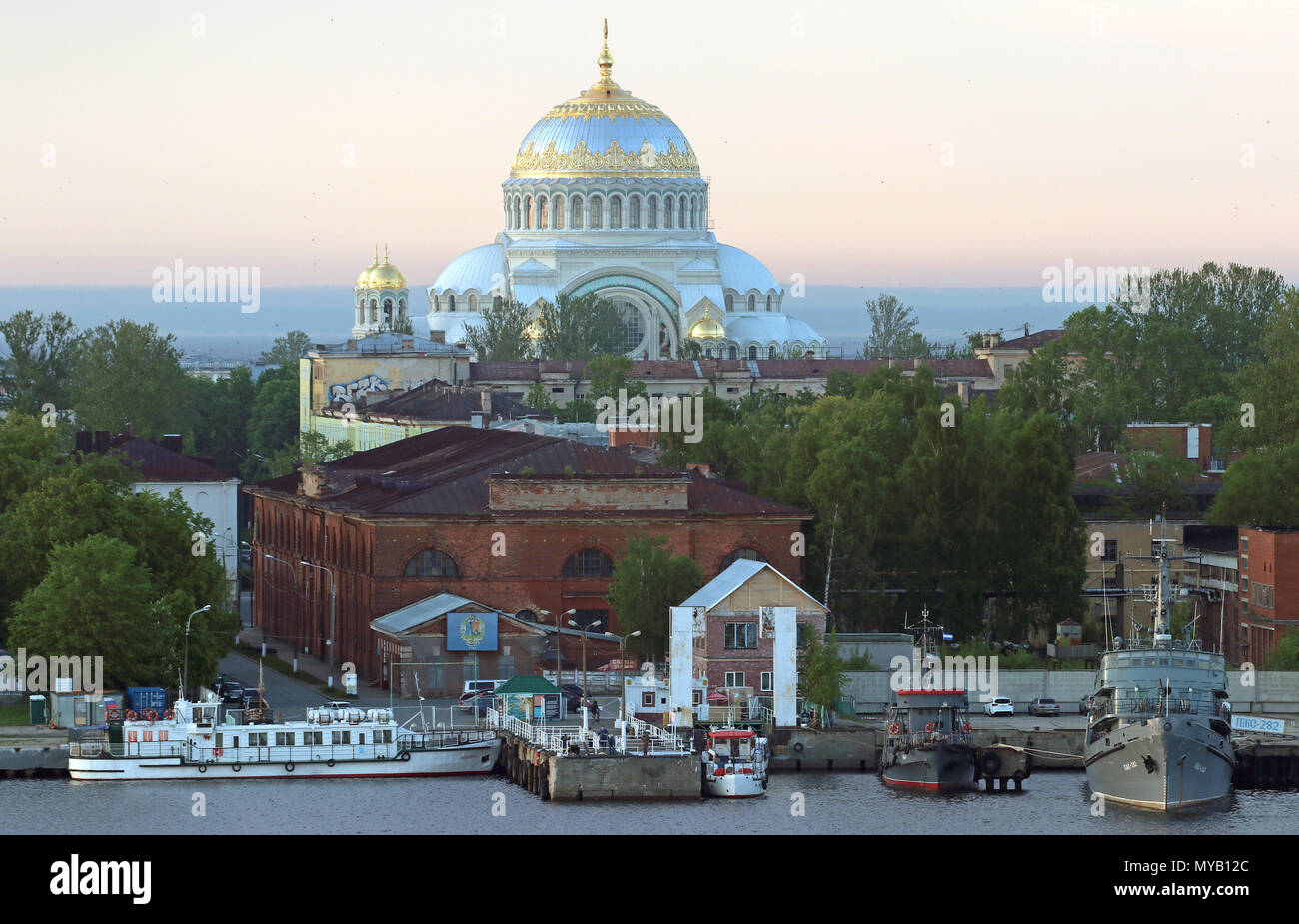 Während in den alten Hafen von Kronstadt in St. Petersburg historische und moderne militärische und zivile Schiffe sind angedockt, die Naval Kathedrale erhebt sich im Hintergrund. Zwischen 1903-1913 gebaut, der russisch-orthodoxen Kirche wurde in der Form eines riesigen Moschee von Istanbul Hagia Sophia erbaut. In der Dämmerung 10.06. 2017. Heute Kronstadt ist ein Teil der Millionen - starke Stadt St. Petersburg. Es wurde von Zar Peter errichtet, die ich als Marinestützpunkt auf der Ostsee. Die Matrosen von Kronstadt ging in die Geschichte für verschiedene Aufstände. Foto: Peter Zimmermann/dpa-Zentralbild/ZB | Verwendung weltweit Stockfoto