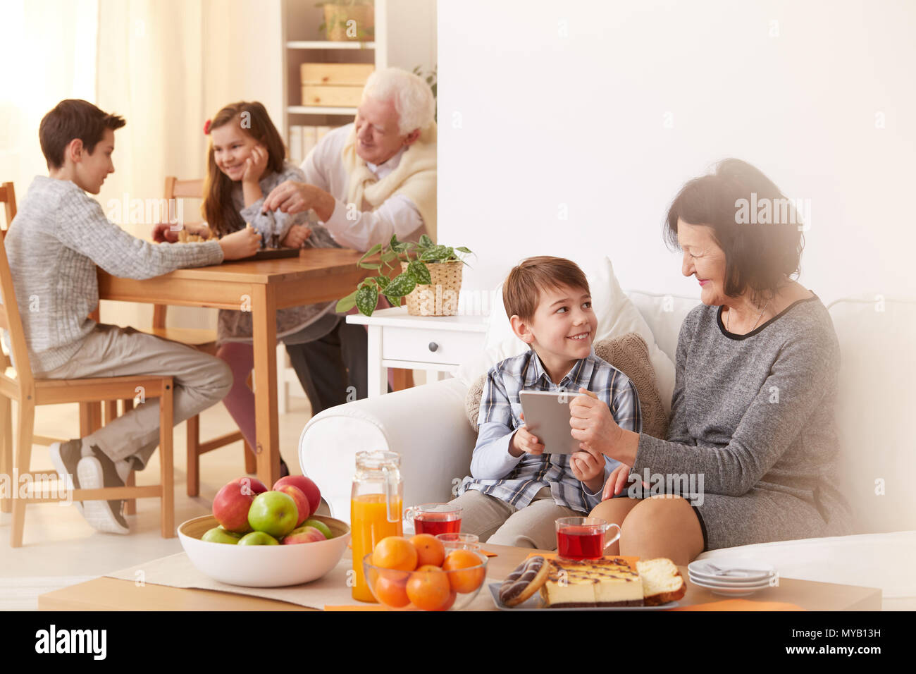Happy Enkel besuchen ihre Großeltern und Zeit mit ihnen verbringen. Stockfoto
