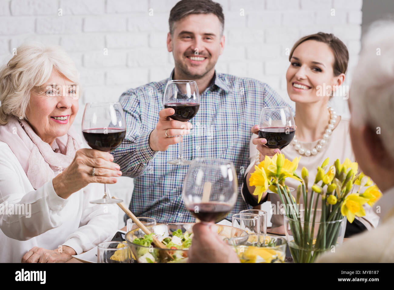 Familie Trinken Toast für ältere Menschen, die Gläser mit Rotwein, lächelnd Stockfoto