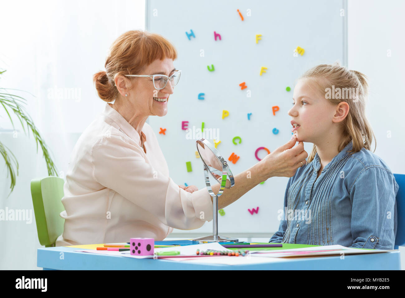 Logopädin Trainieren mit einem Kind in ihrem hellen Büro Stockfoto