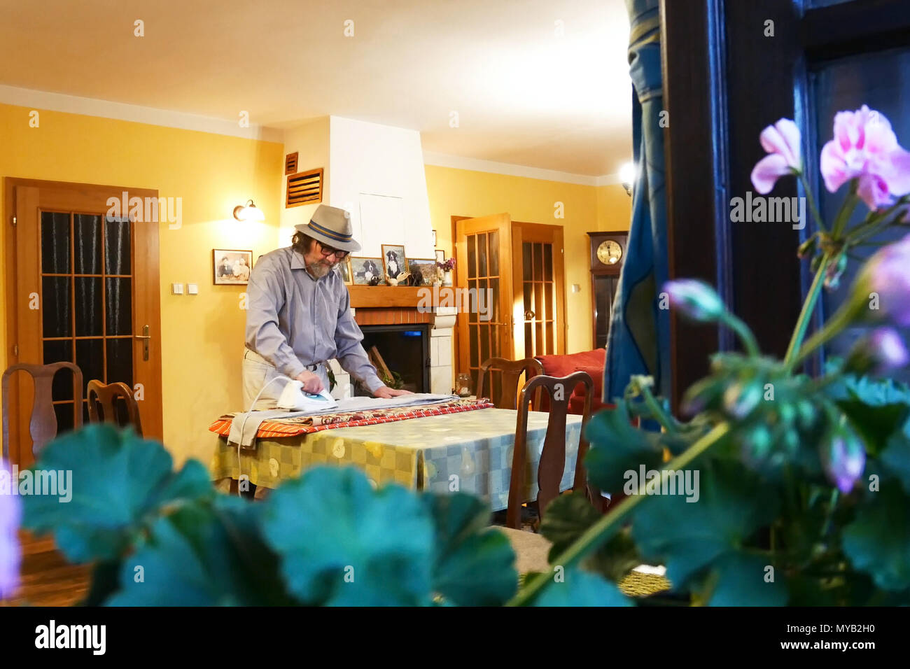 Single Mann drücken Kleidung im Wohnzimmer. Blick durch das Fenster. Stockfoto