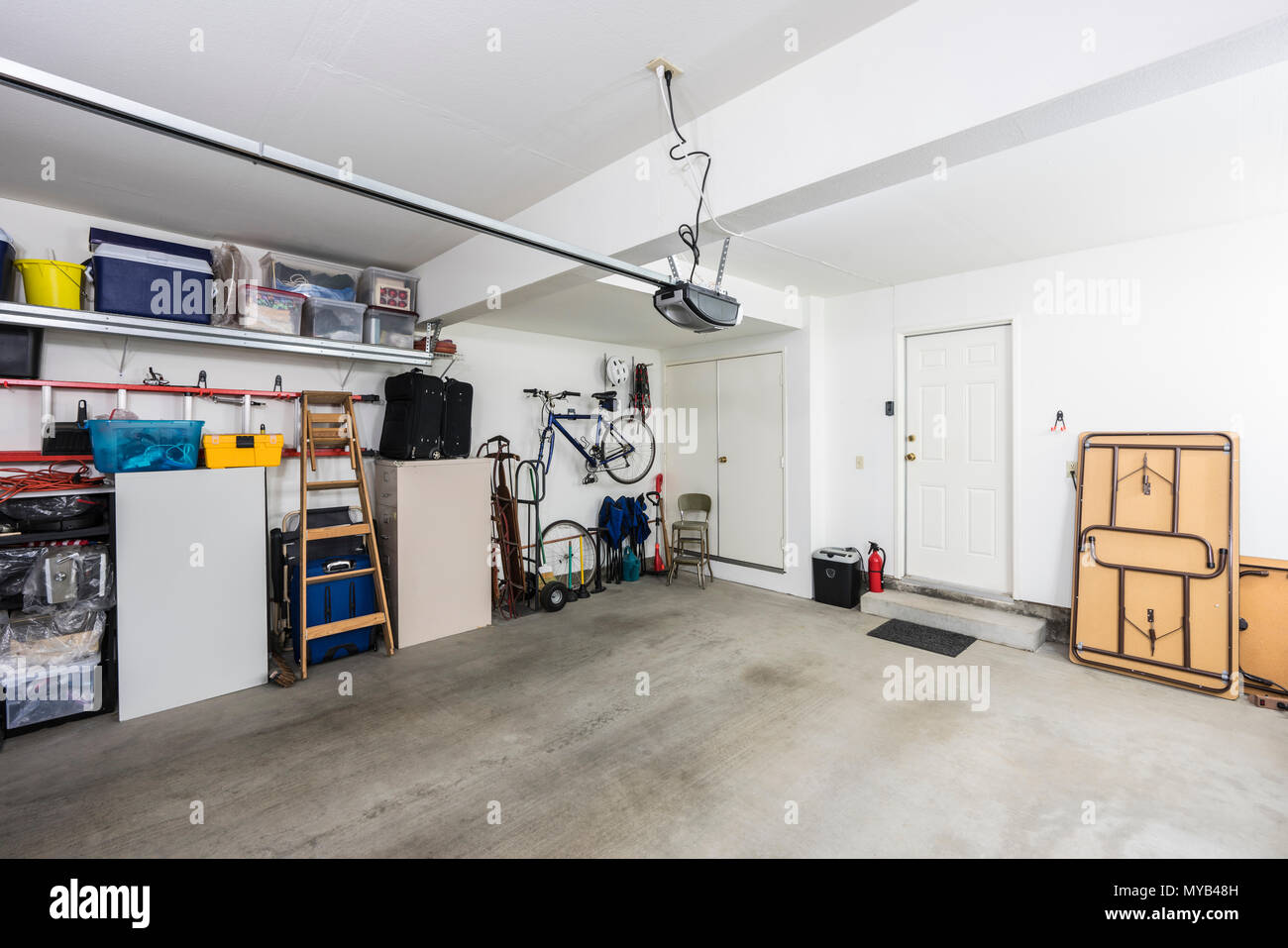 Sauber organisiert vorstädtischen Wohnviertel Garage für zwei Autos mit Werkzeugen, Aktenschränke und Sportgeräte. Stockfoto