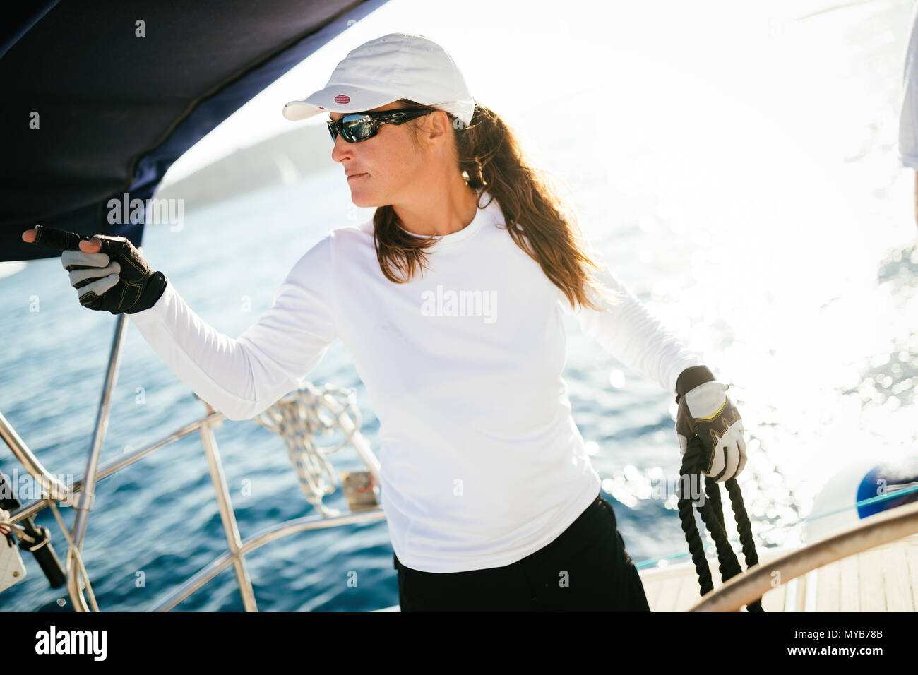Attraktive starke Frau Segeln mit Ihrem Boot Stockfoto