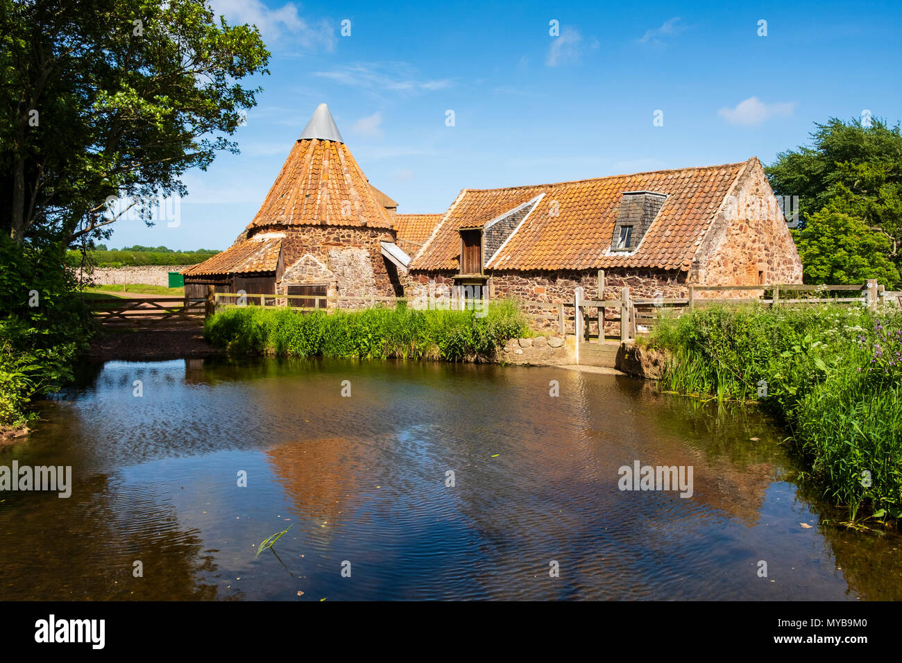 Anzeigen von Preston Mühle mit Wasserrad, mühlteich und doocot am Fluss Tyne in East Lothian, Schottland, Großbritannien Stockfoto