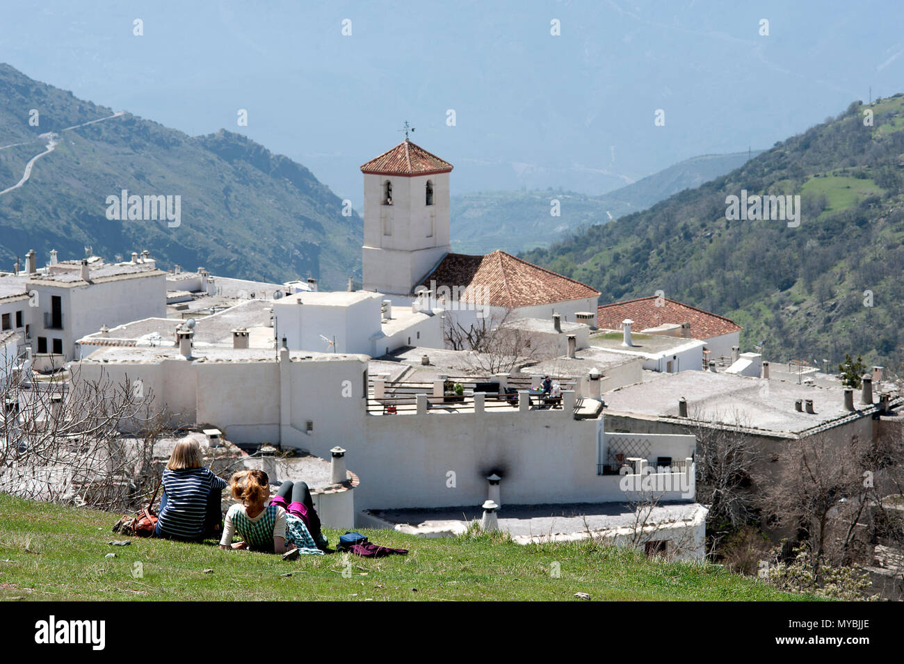 Touristen genießen die Sonne und das Panorama der Alpujarran Dorf Capileira hoch oben in den Bergen der Sierra Nevada in Spanien Andalusien. Stockfoto