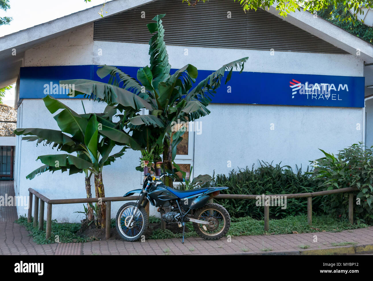 Latam Reisebüro Gebäude mit Motorrad geparkt Neben Bananenstauden, Hanga Roa, Easter Island, Chile Stockfoto