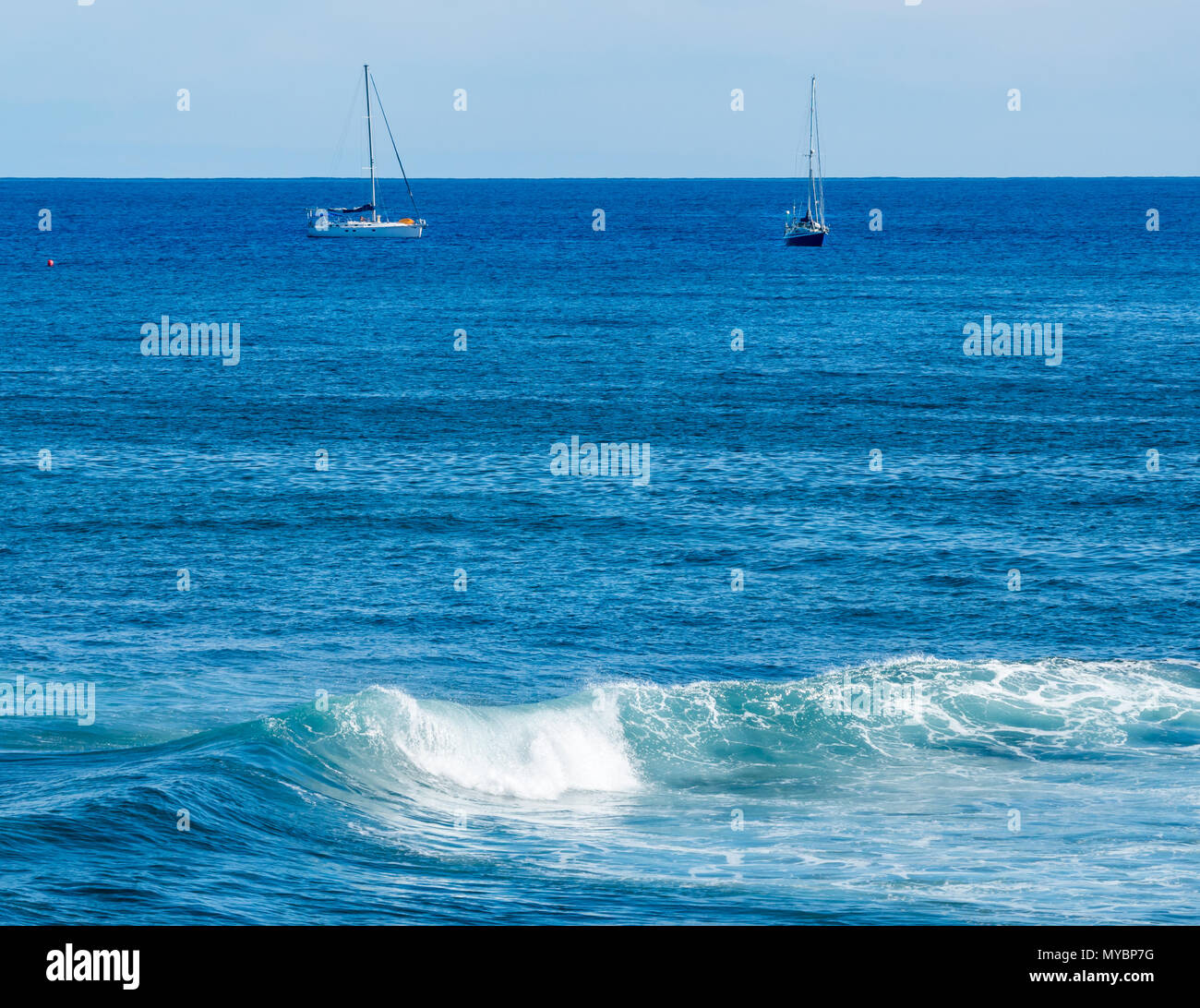 Idyllischer Blick auf den Pazifik mit verankerten Segelbooten und Wellenkamm Stockfoto