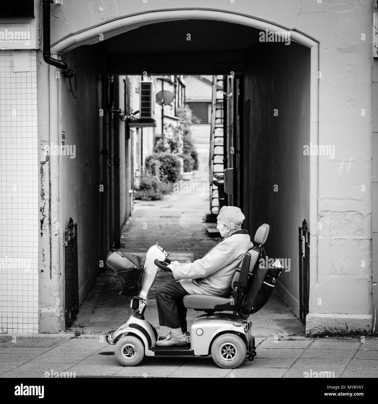 Alten Mann auf einer Behinderung scooter in der schottischen Stadt im Hochland von Nairn, Großbritannien Stockfoto