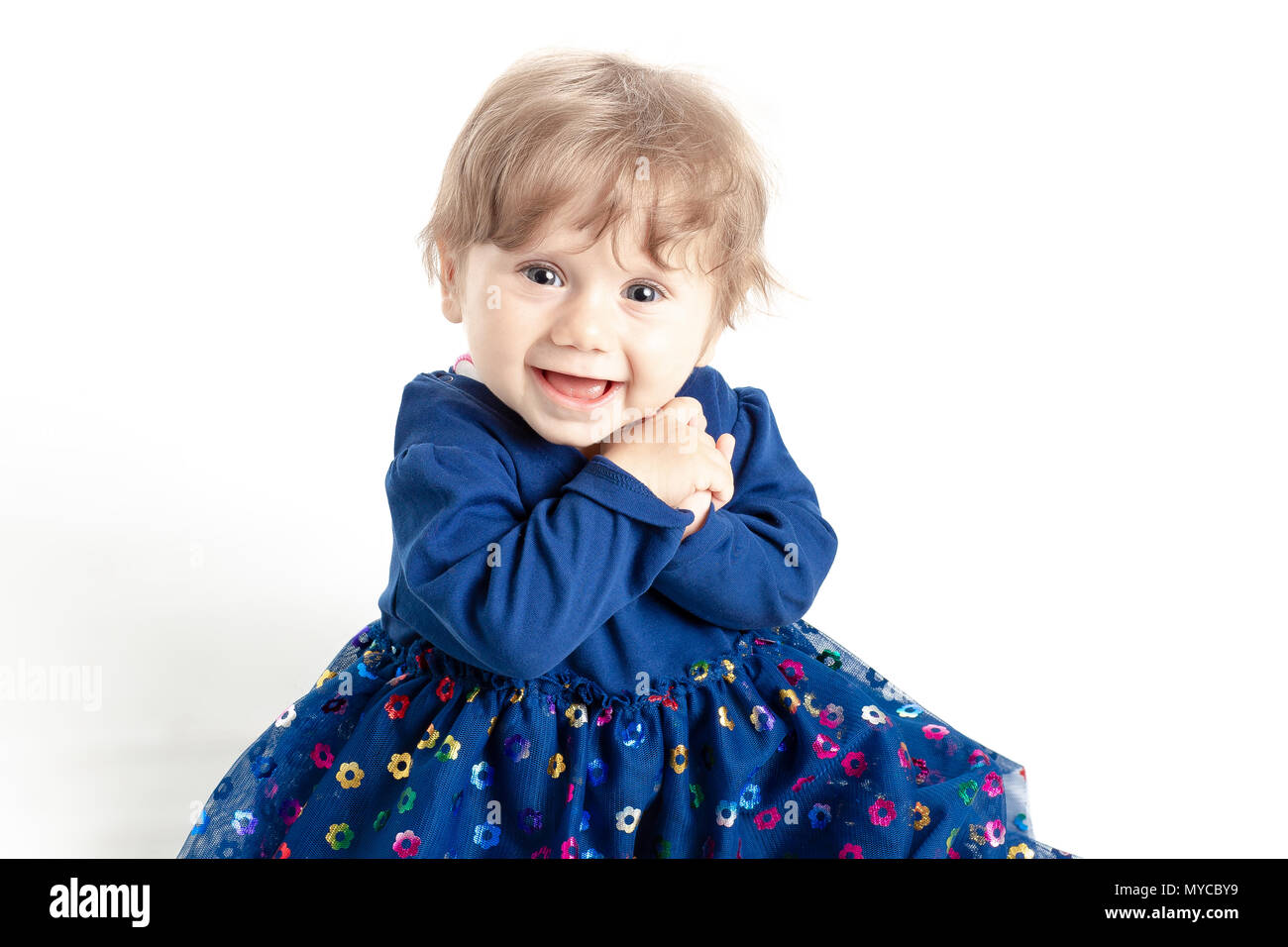 Portrait von Happy Baby Mädchen, 1 Jahr alt mit blauen Augen und Kleid in Studio posieren. Weißer Hintergrund. Konzept Das Glück. Stockfoto