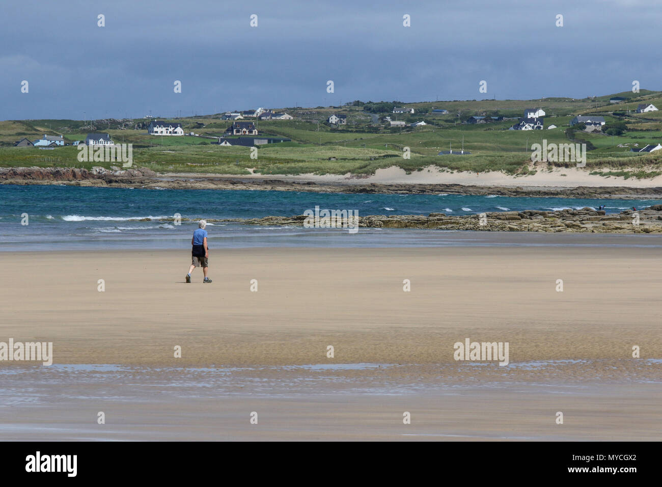Eine Person, die an einem Sandstrand in Irland an Ballyhiernan, County Donegal. Stockfoto