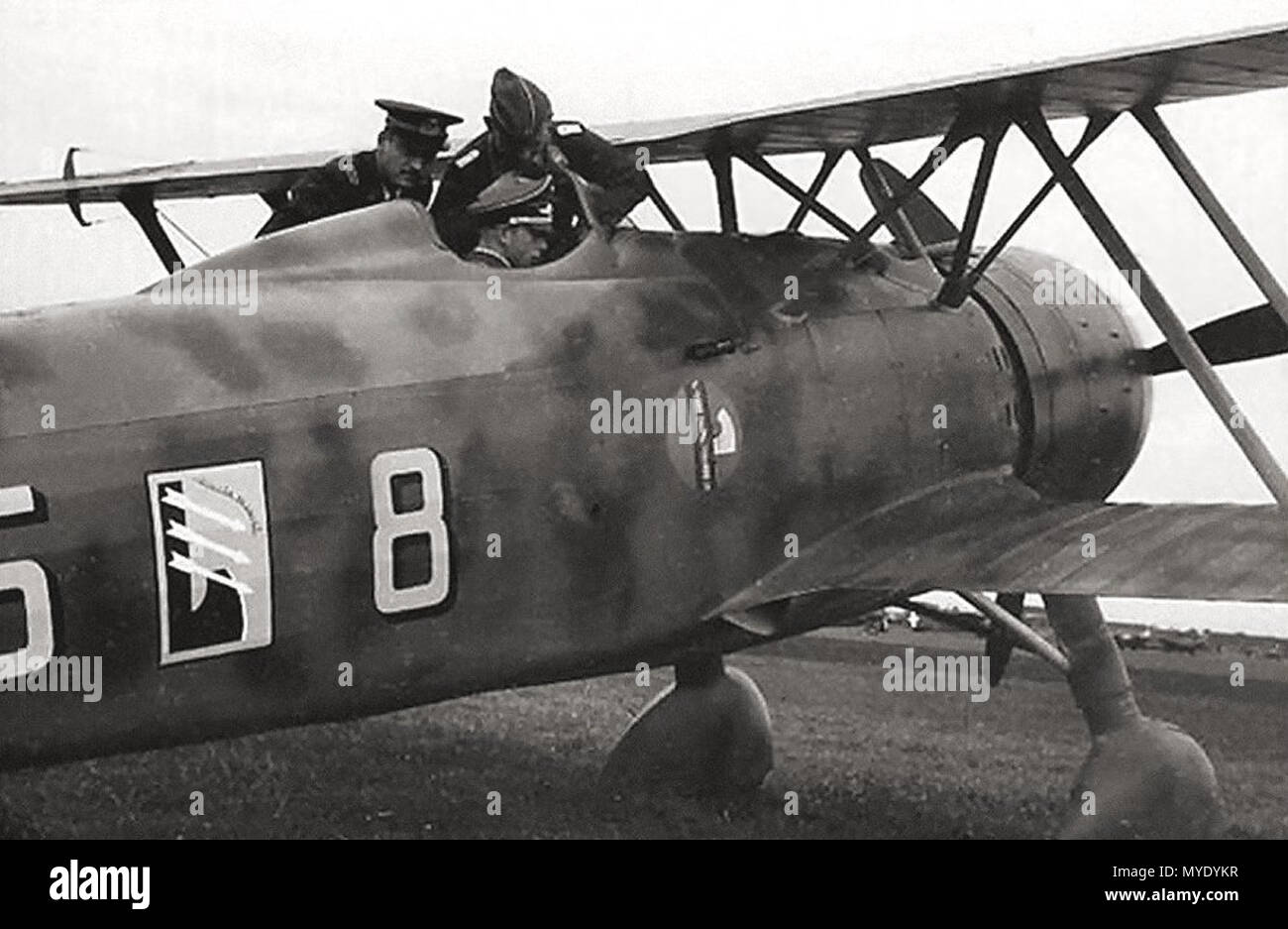 . Englisch: Ein deutscher Offizier im Cockpit sitzen untersucht das Bedienfeld eines Fiat CR.42 'Falco' der 85. Staffel, XVIII Gruppe C.T. (Terrestrische Fighter Group), 56th Wing C.T., italienische Luft Corp, die Schlacht um England, Belgien 1940. 1940. Unbekannt 179 Fiat CR.42 - Belgien Stockfoto