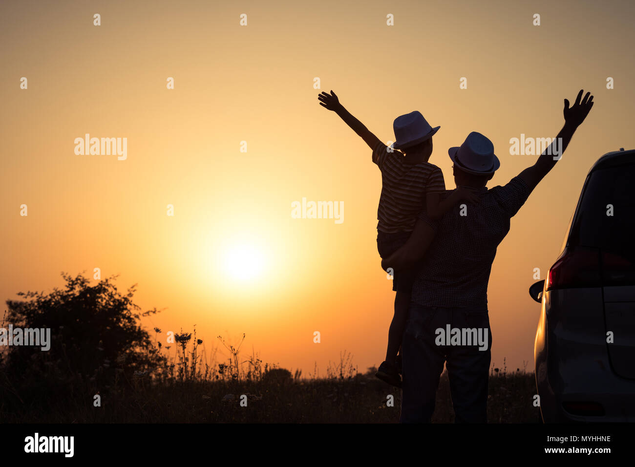 Vater und Sohn spielen im Park bei Sonnenuntergang. Leute, die Spaß auf dem Feld. Konzept der freundliche Familie und der Sommerferien. Stockfoto