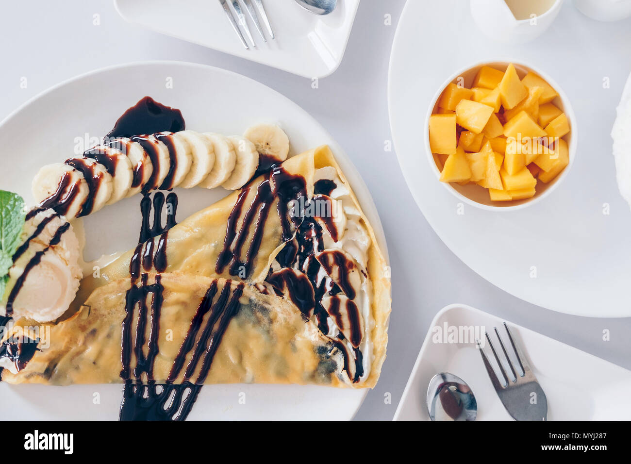 Bingsu Mango (Koreanische Desserts) rasiert Eis Desserts mit Mango auf der Oberseite und gesüßte Kondensmilch, Banane kalten Krepp (japanische Desserts), Crepe mit c Stockfoto