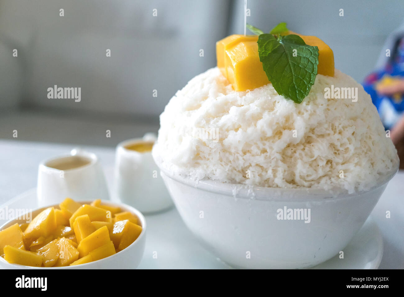 Bingsu Mango (Koreanische Desserts) rasiert Eis Desserts mit Mango auf der Oberseite und gesüßte Kondensmilch und kondensierten mango Saft. Stockfoto