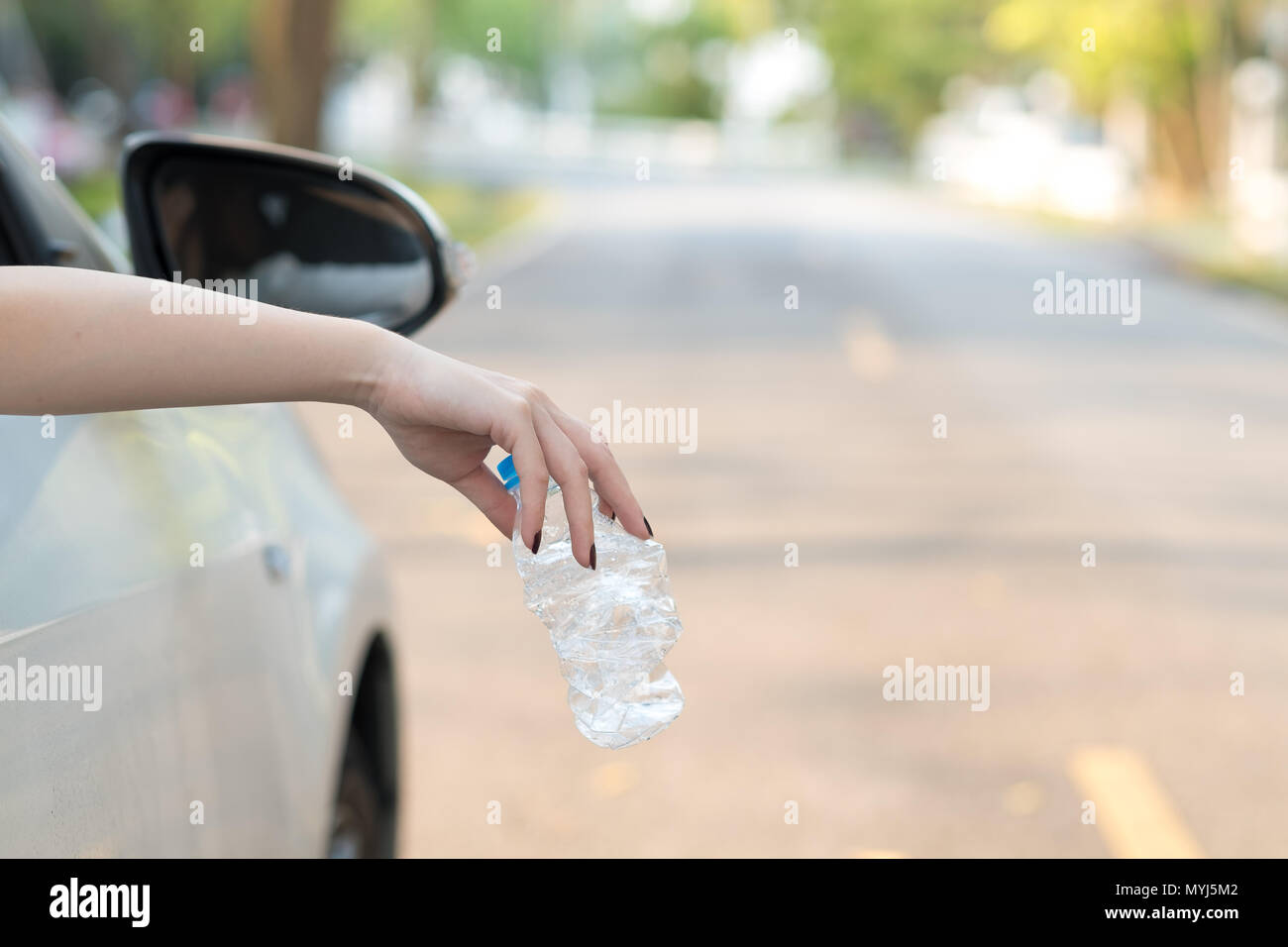 Hand werfen Kunststoff Flasche auf der Straße Stockfoto