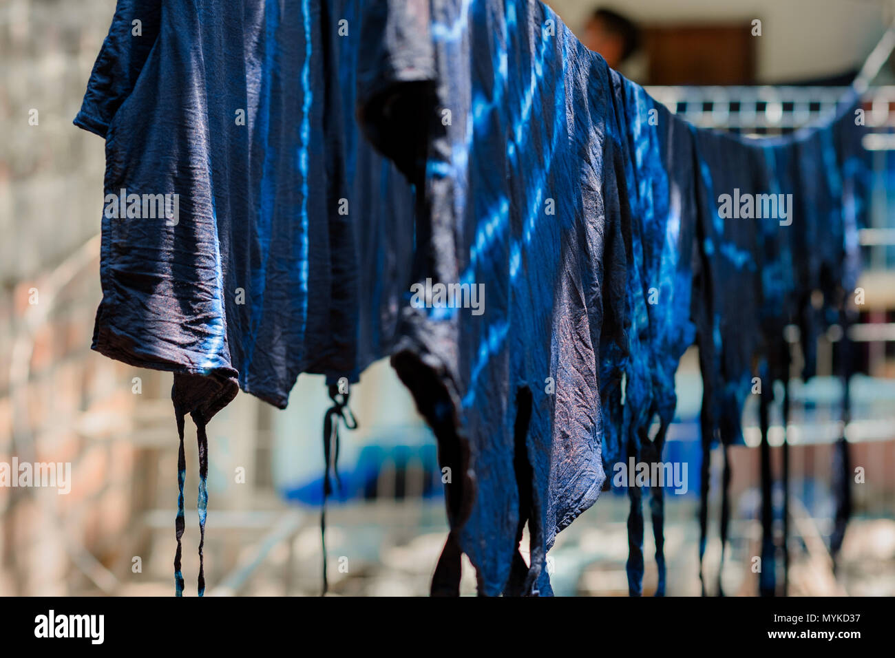 Indigo-gefärbter Kleidung, nachdem im Färbebad verarbeitet wird, auf einer Wäscheleine in einem Kleidung Workshop in Santiago Nonualco, El Salvador aufgehängt. Stockfoto