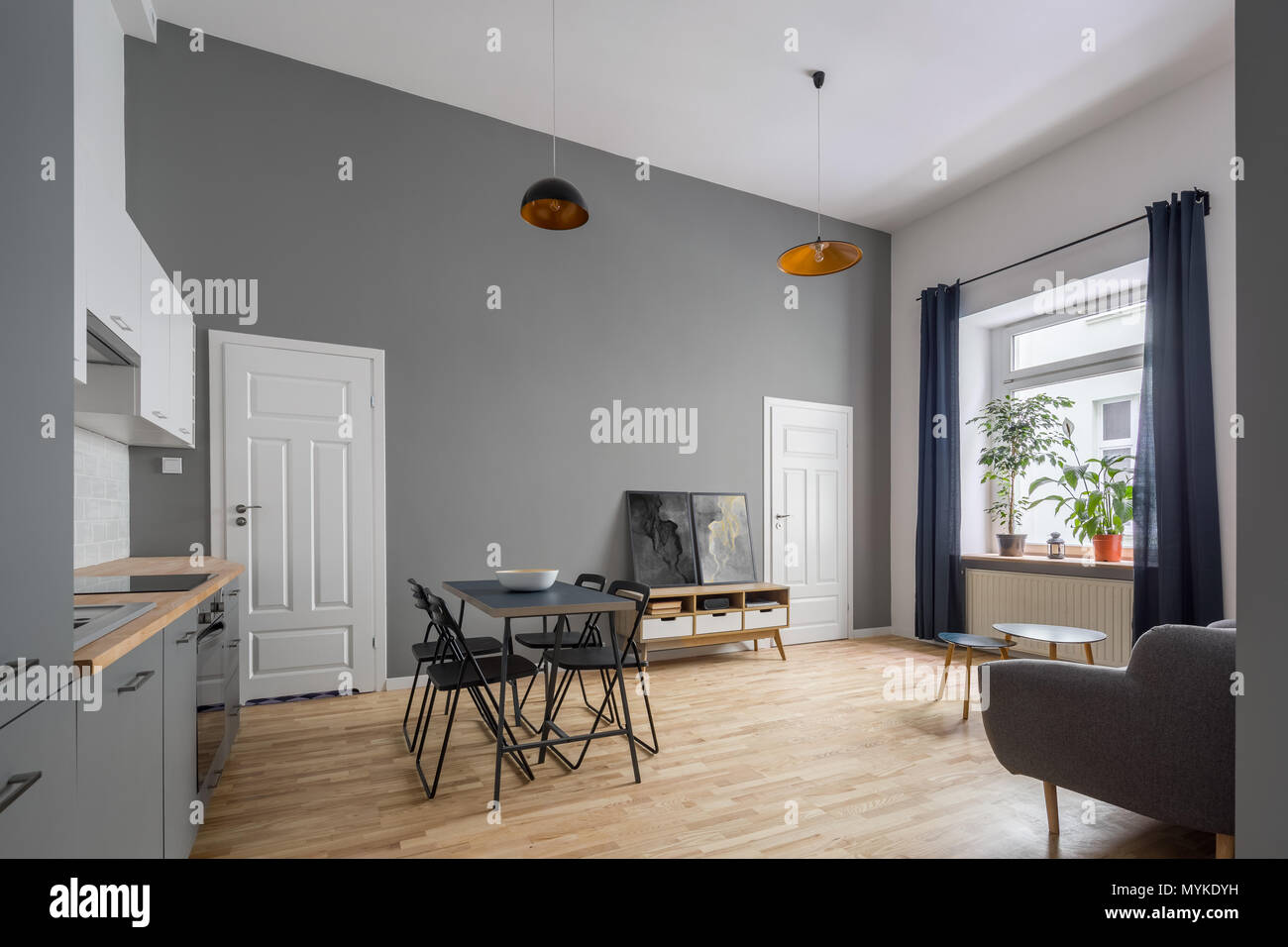 Moderne offene Wohnung in Grau mit Küchenzeile und einfache Tabelle Stockfoto