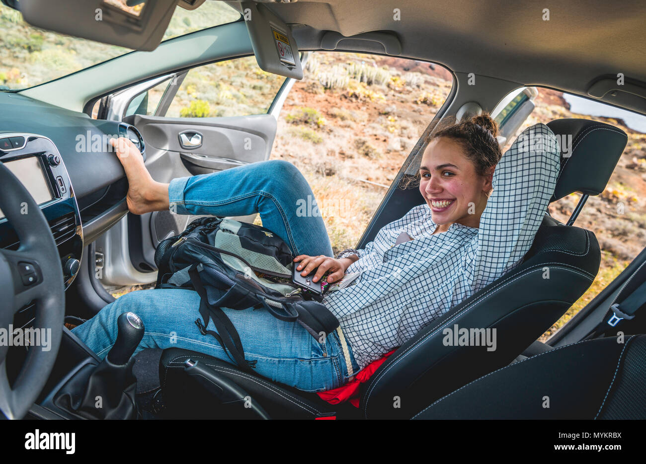 Junge Frau sitzt entspannt in Ihrem Auto und lacht, Urlaub, Teneriffa, Kanarische Inseln, Spanien Stockfoto