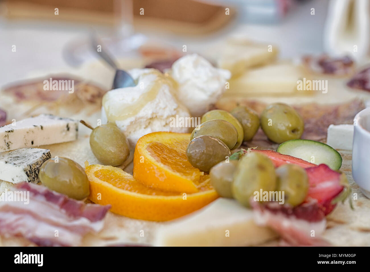 Köstliche italienische Snacks wie Oliven, Ricotta, Käse, Schinken, Erdbeeren, orange Stockfoto