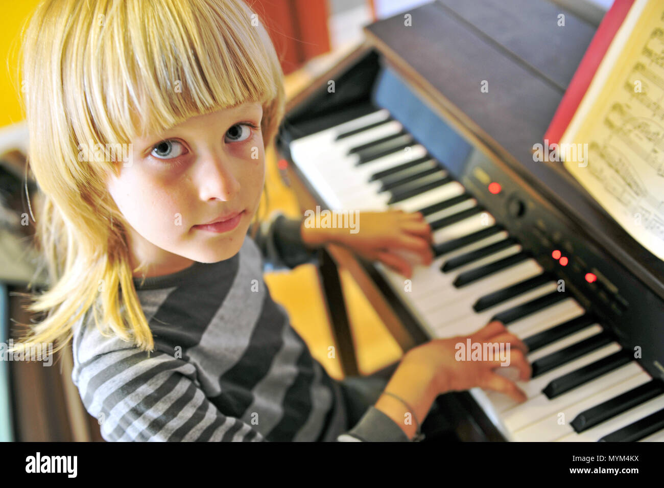 Süßer kleiner Junge spielt Piano Stockfoto