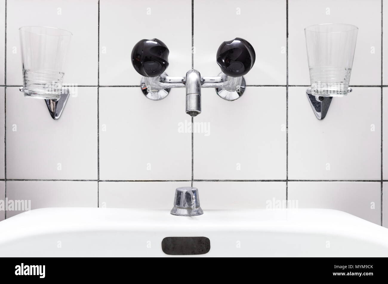 Waschbecken und Wasserhahn im Badezimmer, schwarze Knöpfe Stockfoto
